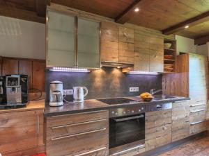 米特西尔Rustic country house in Mittersill near ski area的厨房配有木制橱柜和炉灶烤箱。