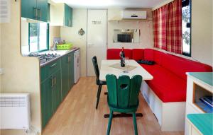 特罗吉尔Amazing stacaravan In Trogir With Kitchen的一个带桌子和红色沙发的小厨房