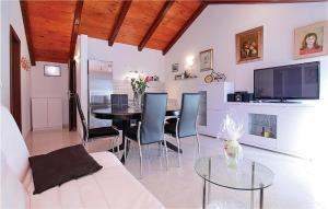 尼亚卢卡4 Bedroom Amazing Home In Vela Luka的客厅配有桌椅和电视。