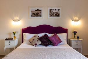 陶尔米纳瓦伦蒂娜旅馆的一间卧室配有带枕头的床和2个床头柜