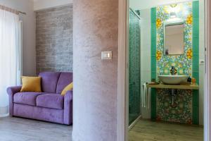 陶尔米纳瓦伦蒂娜旅馆的客厅配有紫色沙发和镜子