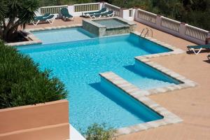苏昂博Petit Paradis的庭院里的一个蓝色海水游泳池