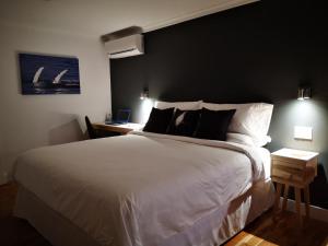 泰道沙克Au Cachalot Caché le gîte hôtel的一间卧室配有一张白色大床和黑色墙壁