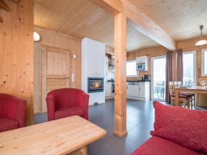 上陶恩Chalet in Hohentauern near ski area with sauna的客厅配有红色椅子和桌子