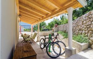 格鲁达Beautiful Home In Gruda With Kitchen的两辆自行车停在一个庭院的木凉棚下