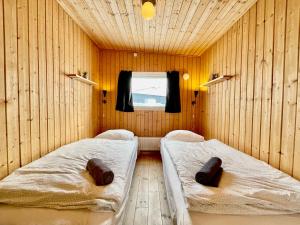 努克Inuk Hostels的配有木墙和窗户的客房内的两张床
