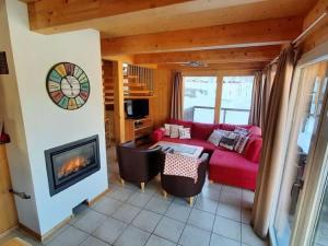 穆劳附近圣格奥尔根Chalet in St Georgen ob Murau with hot tub的客厅设有红色的沙发和壁炉