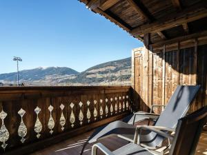 平茨高谷地霍勒尔斯巴赫Apartment in Hollersbach with sauna near ski area的阳台的两把椅子,背景是群山