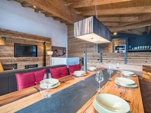 皮森多夫Luxurious holiday home in Piesendorf with sauna的用餐室配有长木桌子和红色椅子