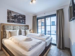 皮森多夫Luxurious holiday home in Piesendorf with sauna的一间卧室设有两张床和大窗户
