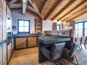 皮森多夫Luxurious holiday home in Piesendorf with sauna的厨房配有大型黑色柜台和椅子
