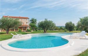 罗维尼Stunning Home In Rovinj With Wifi的一个带椅子的游泳池以及一座房子