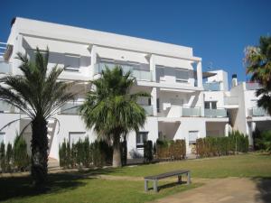 德尼亚Apartamentos Fercamar Denia的一座白色的建筑,前面有棕榈树