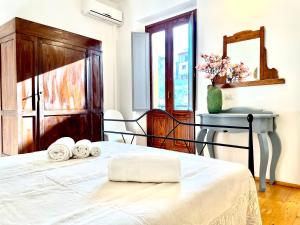 巴里萨尔多Le Corti Sarde Apartments的一间卧室配有一张床,上面有两条可移动的毛巾