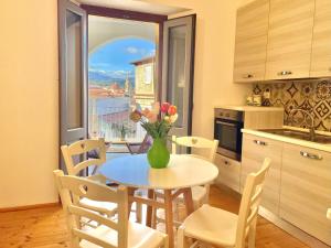 巴里萨尔多Le Corti Sarde Apartments的厨房配有一张桌子,上面放着花瓶