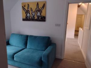 亚瑟斯通The Wheatsheaf Inn的客厅里一张蓝色的沙发,墙上挂着一幅画