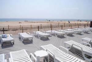 波因特普莱森特海滩风拂汽车旅馆的海滩上一束白色的椅子和桌子