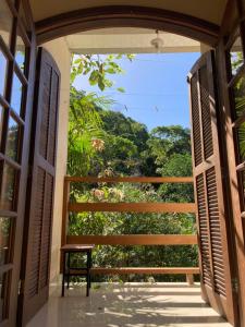 特林达德Suíte na Montanha的通往景观阳台的开放式门