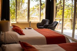 拉利伯塔德德玛别墅酒店的配有两张床铺的客房,设有两把椅子和一扇窗户