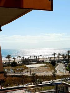 阿利坎特Apartamento con vistas al mar的享有棕榈树海滩和大海的景色