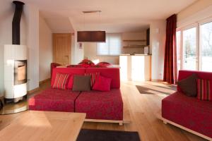 斯图泽姆拉麦森都提格瑞公寓酒店的一间带红色沙发的客厅和一间厨房