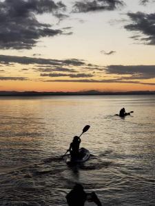 莫约加尔帕Cabañas Privadas Dilany的两人在日落时分在水面划皮划艇