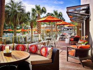 希尔顿黑德岛Sonesta Resort Hilton Head Island的天井配有沙发、桌子和遮阳伞