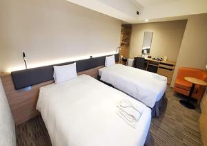 东京KEIKYU EX INN Haneda的酒店客房配有两张床和一张书桌