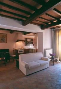 巴尔贝里诺瓦尔德尔萨托雷伊欧洛公寓式酒店的一间带白色沙发的客厅和一间厨房