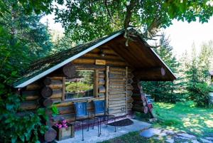 HopeHope Alaska's Bear Creek Lodge的一个带椅子和窗户的小小木屋