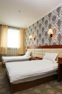 乌兰巴托指南酒店的酒店客房带两张床和一面墙