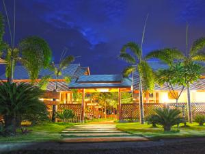 夜功府Baan Siriporn Resort - โรงแรมบ้านศิริพร รีสอร์ท的一座棕榈树在晚上的房屋