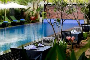 暹粒高棉公馆精品酒店的池畔餐厅,配有桌椅