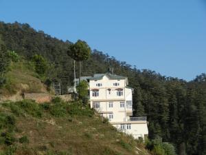 西姆拉Vatsalyam Home Stay的山边的白色房子