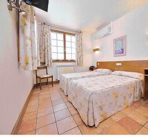 Olave罗伦托旅馆的一间设有两张床和窗户的大卧室