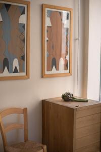 利马索尔市中心一室公寓的一张桌子、一把椅子和两张墙上的照片