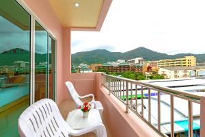 芭东海滩Phusita Hotel - SHA Certified的阳台配有2把白色椅子,享有城市美景