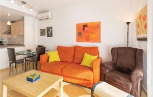 罗尔丹曼努埃尔艾斯塔特公寓的客厅配有橙色沙发和两把椅子
