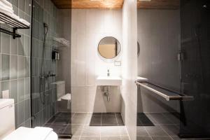 台东旅人驿站日暮微旅的一间带水槽、淋浴和镜子的浴室