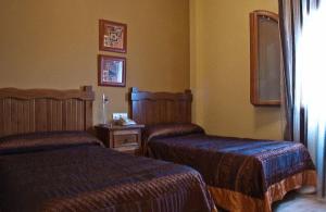 Alcaracejos米格尔​​安赫尔乡村酒店的酒店客房设有两张床和一张桌子。