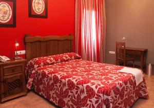 Alcaracejos米格尔​​安赫尔乡村酒店的一间卧室设有一张床和红色的墙壁