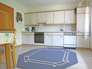 梅德巴赫Secluded Apartment in Medebach with Terrace的厨房配有白色橱柜和蓝色地毯。