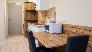 塞斯豪普特Gästehaus - Boardinghouse Magnetsried的厨房配有木桌和微波炉