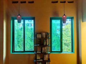 佛山Foshan Cuba Youth Hostel的书架房间的两扇窗户