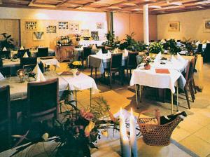 莱克斯拉克斯西霍夫宾馆的一间设有白色桌椅的餐厅,种植了植物
