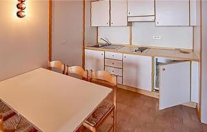 法申Nice Apartment In Vason With Kitchen的厨房配有白色橱柜和桌椅