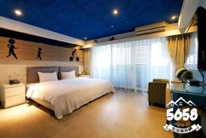 高雄R8环保商旅的一间卧室设有一张大床和蓝色的天花板