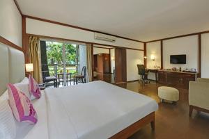 班加罗尔Royal Orchid Resort & Convention Centre, Yelahanka Bangalore的一间带大床的卧室和一间客厅