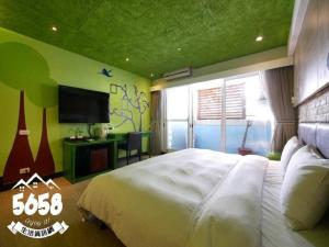 高雄R8环保商旅的卧室配有一张白色大床和电视。