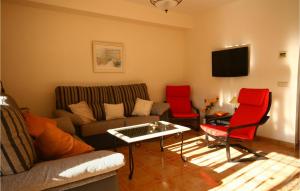 米哈斯科斯塔Jarales Alpha的客厅配有沙发和2把红色椅子